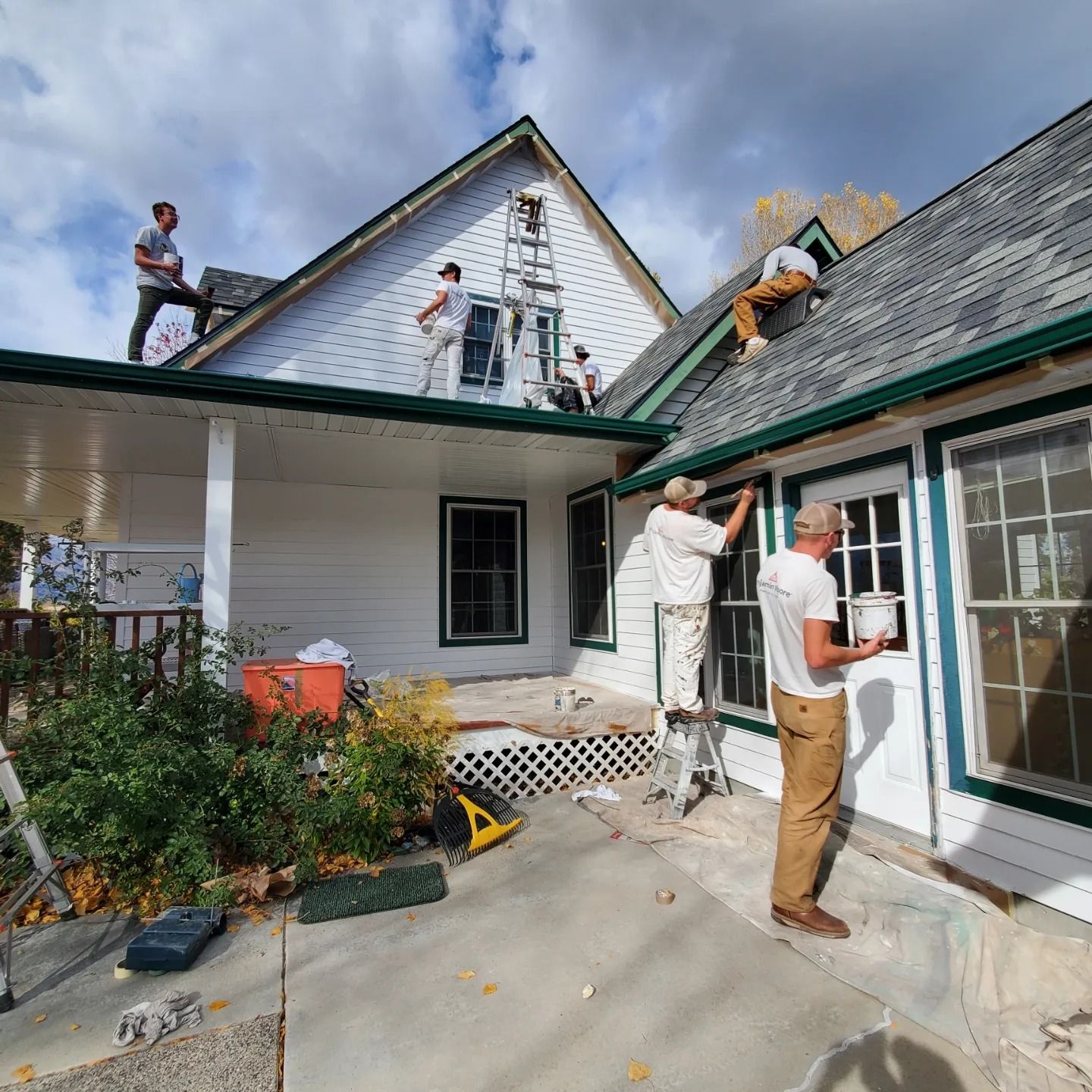 a group of men are painting a white house