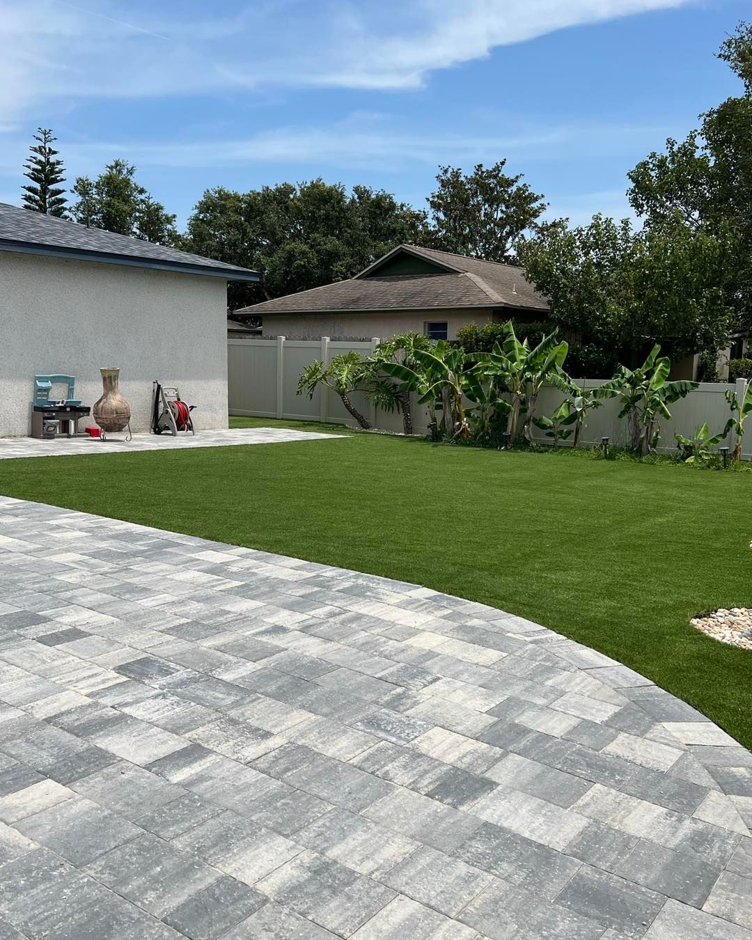 A driveway leading to a house with a lush green lawn