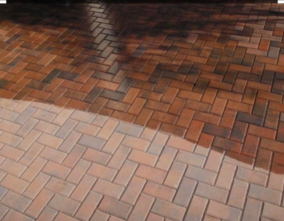 A brick floor with a reflection of a tree in it