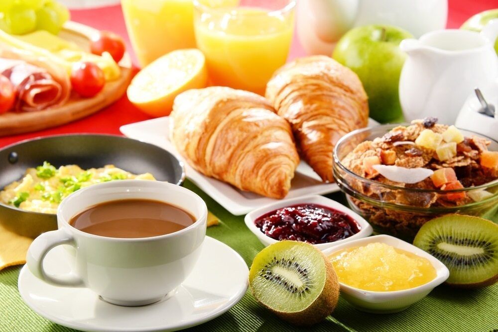 A Table Topped With A Variety Of Food Including Croissants And A Cup Of Coffee — Café and Restaurant in Whitsundays, QLD