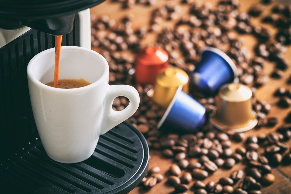 A Cup Of Coffee Is Being Poured Into A Coffee Maker Surrounded By Coffee Bean — Café and Restaurant in Whitsundays, QLD