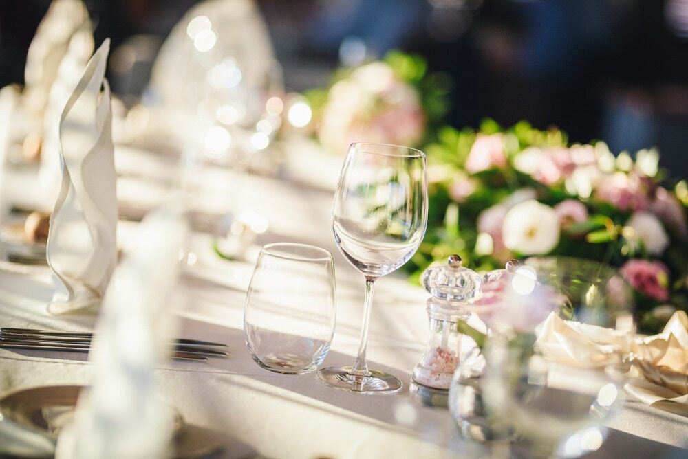 A Table Set For A Wedding Reception With Wine Glasses, Plates, Napkins And Flowers — Café and Restaurant in Whitsundays, QLD