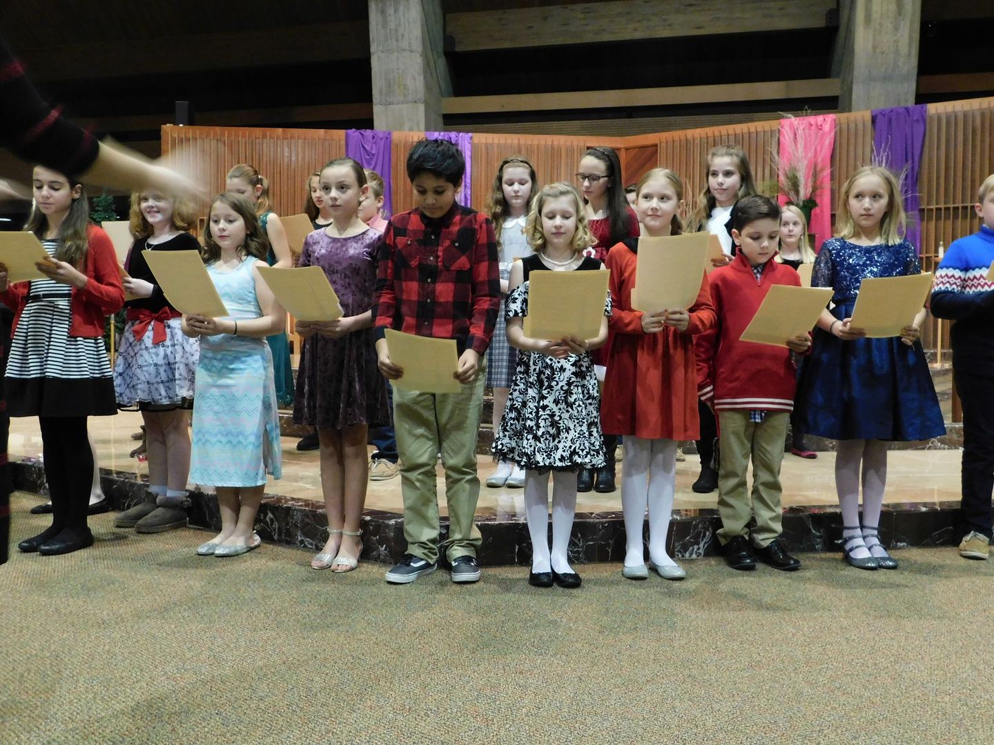 A group of children are singing together in a choir