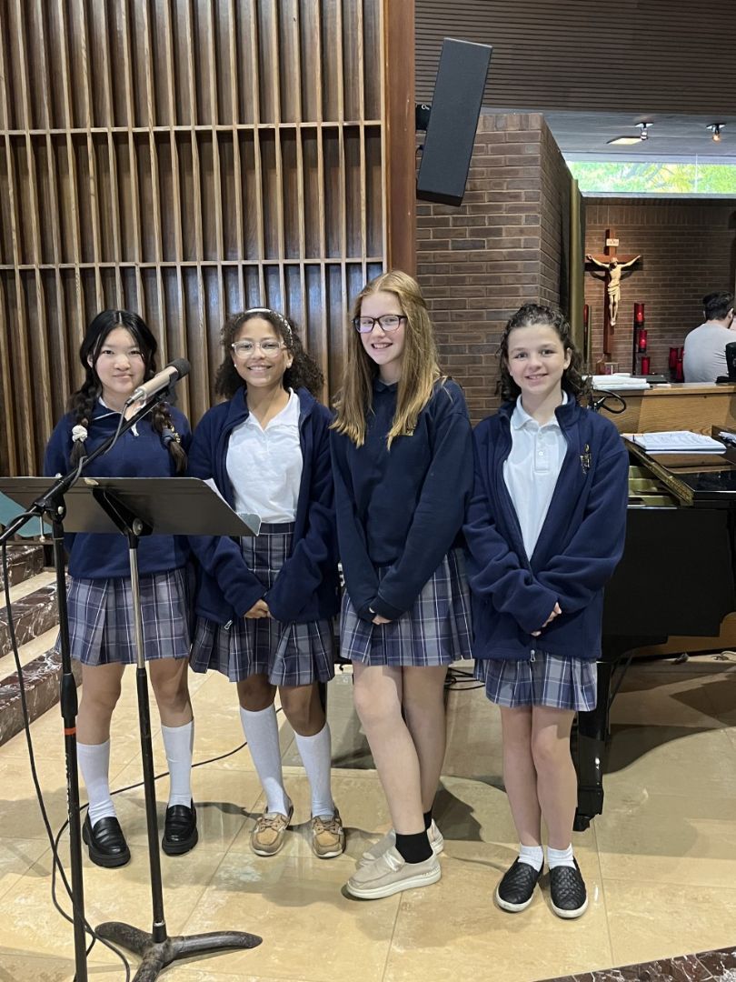 A group of young girls standing in front of microphones in a church