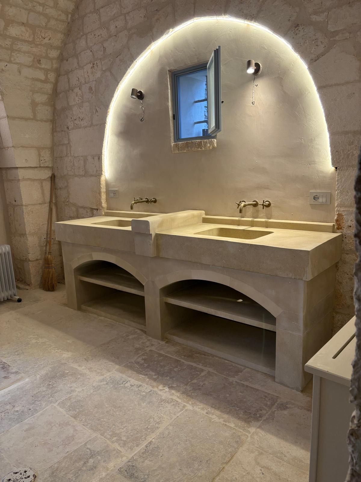 Un bagno con due lavandini e una finestra.