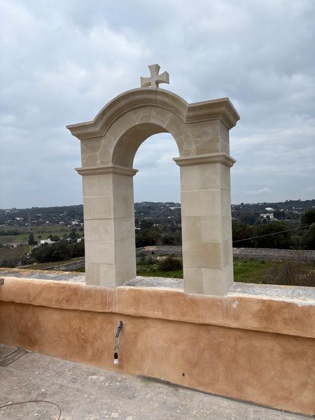 Un arco di pietra con una croce in cima