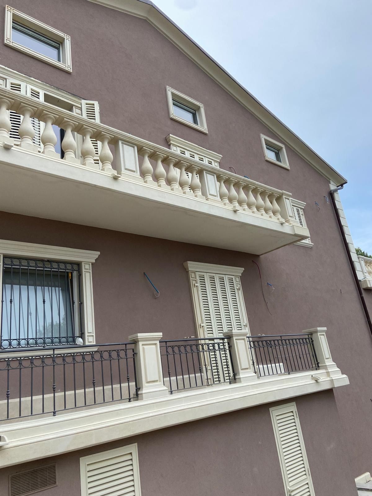 Un grande edificio marrone con balcone e finestre