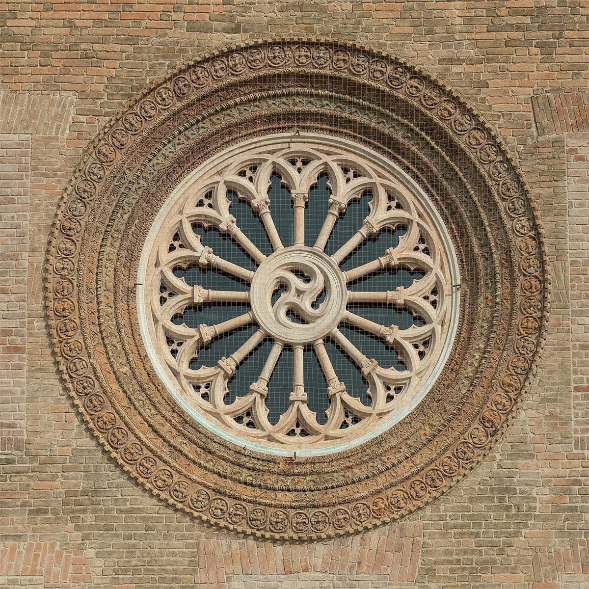 Una finestra rotonda su un muro di mattoni con un disegno celtico