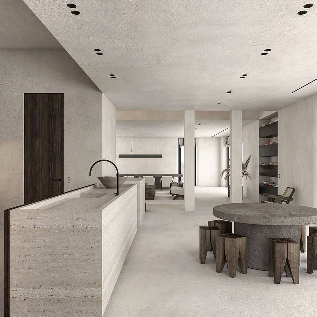 Modern kitchen and dining area with concrete countertops, wooden stools, and neutral tones.