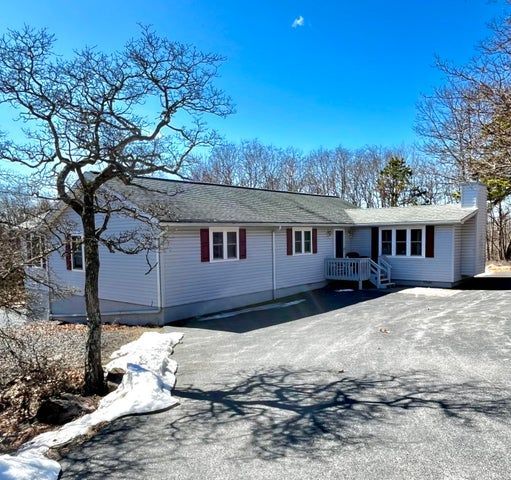 A living room with a couch , chairs , ottoman and a mirror