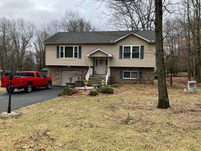 A dining room with a table and chairs and a wooden staircase.