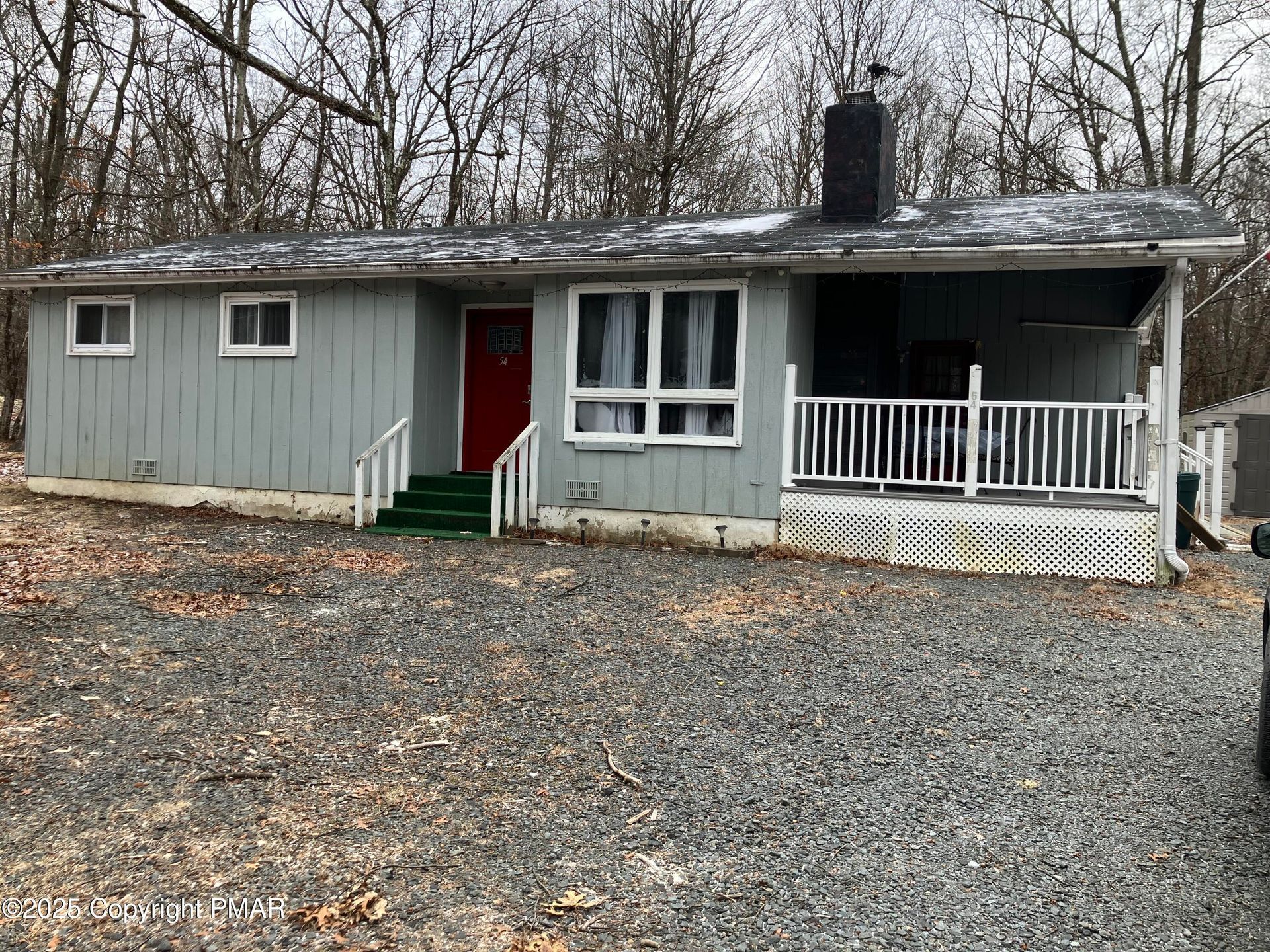 A hotel room with two beds , a couch , a table and a mirror.