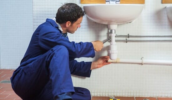 Man fixing a sink — Drain Services in St. Paul, MN