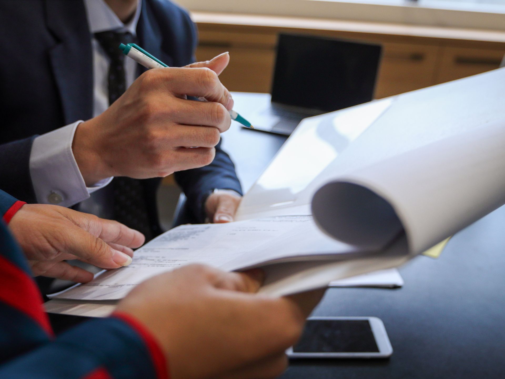 A man in a suit and tie is writing on a piece of paper.