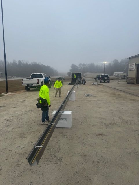 Roofers installing PVC roofing on a flat white roof, city skyline in the background.