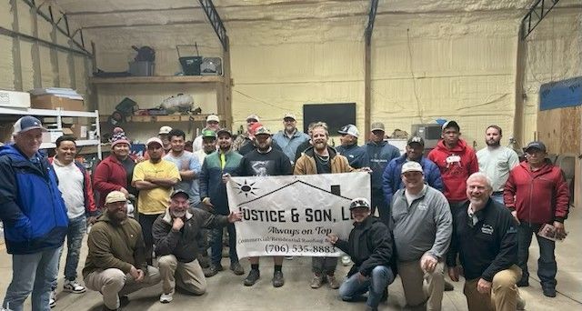 Construction workers in hard hats reviewing plans on a bridge.