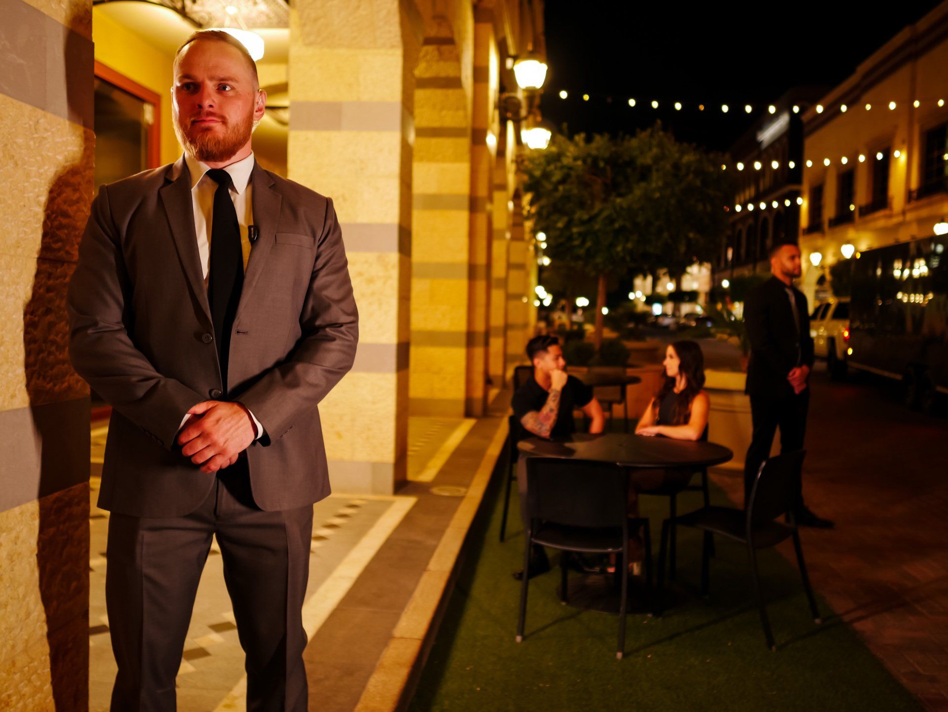 a man in a suit and tie stands in front of a group of people