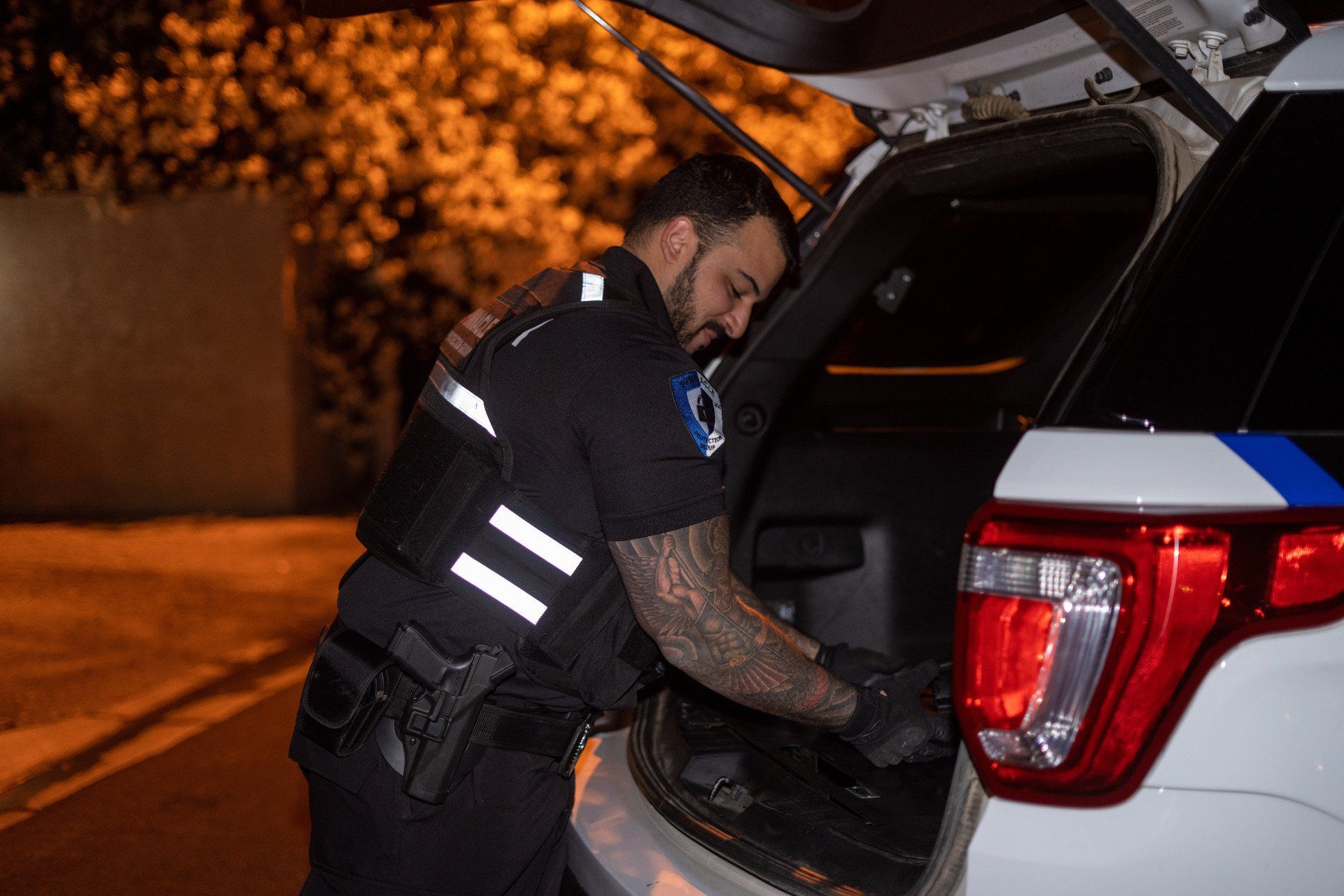a police officer is opening the trunk of a police car .