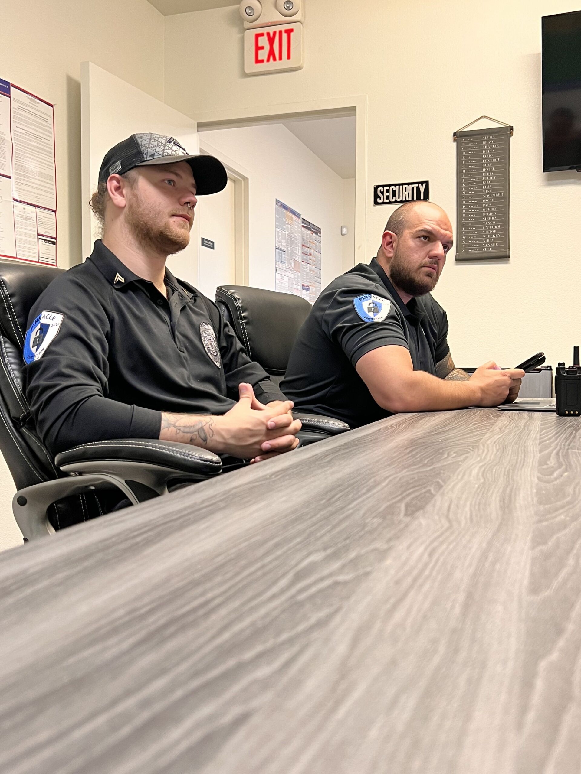 two men are sitting at a table in a conference room .