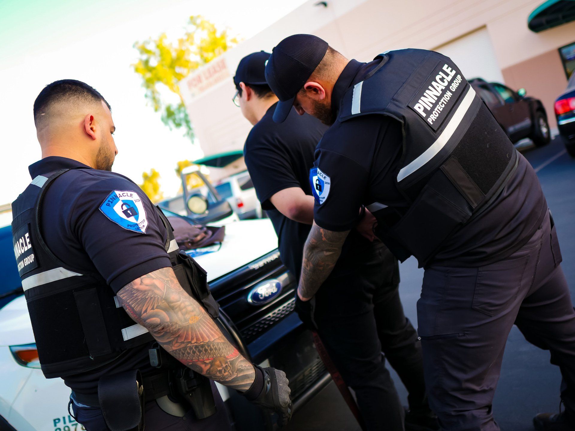 three  security vehicle is parked in front of a large building .