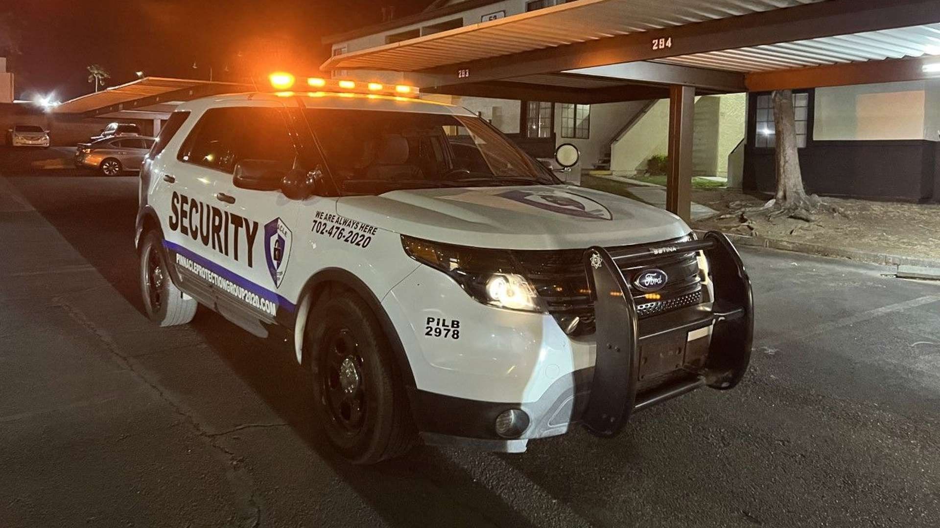 A man in a suit and tie is standing in front of a group of people sitting at tables.