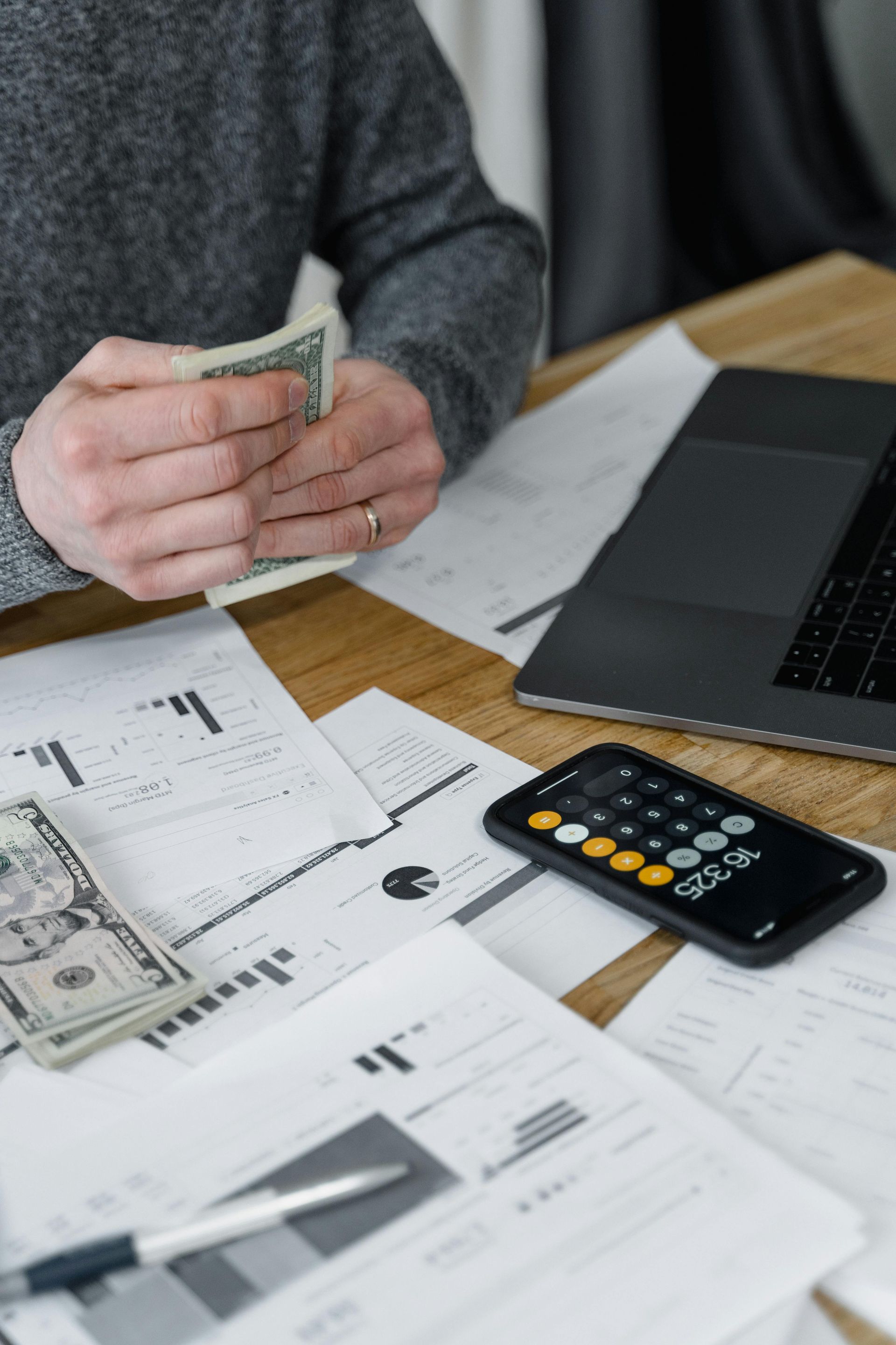 A man is sitting at a table counting money.