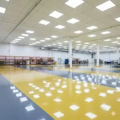 Large, bright industrial space with a shiny yellow and blue epoxy floor