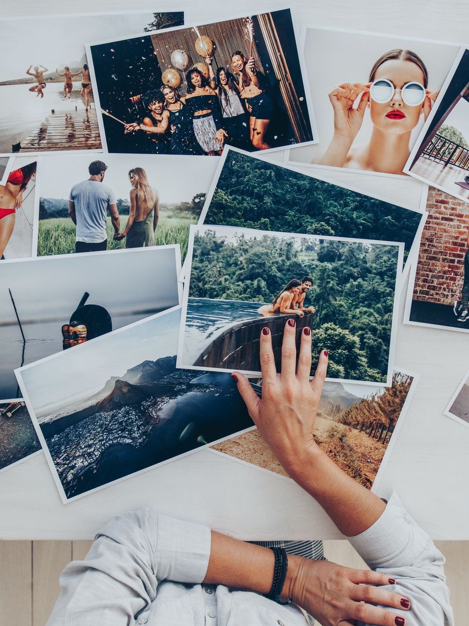 A person is sitting at a table with a bunch of pictures on it.