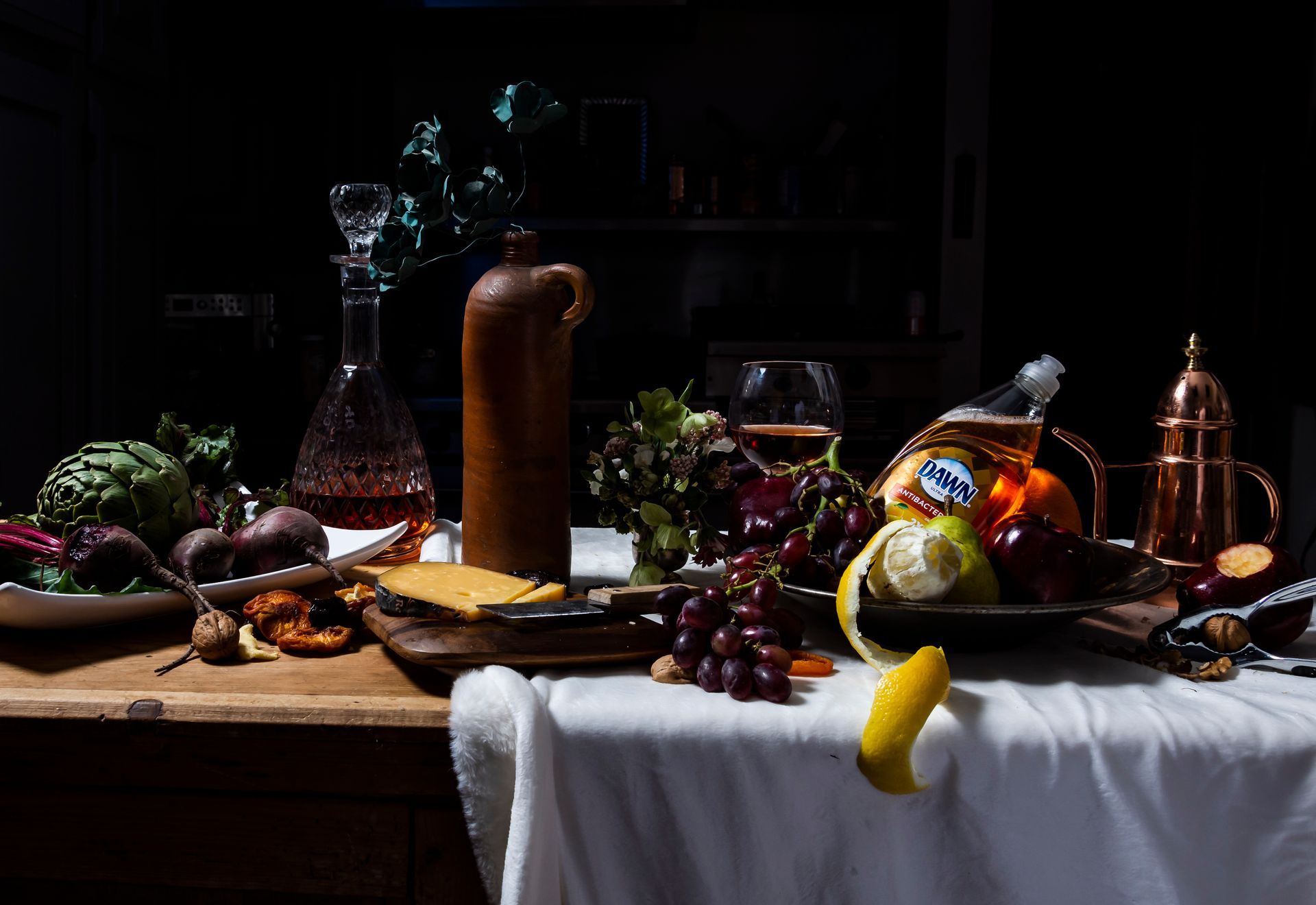 A table topped with fruits and vegetables and a bottle of beer.