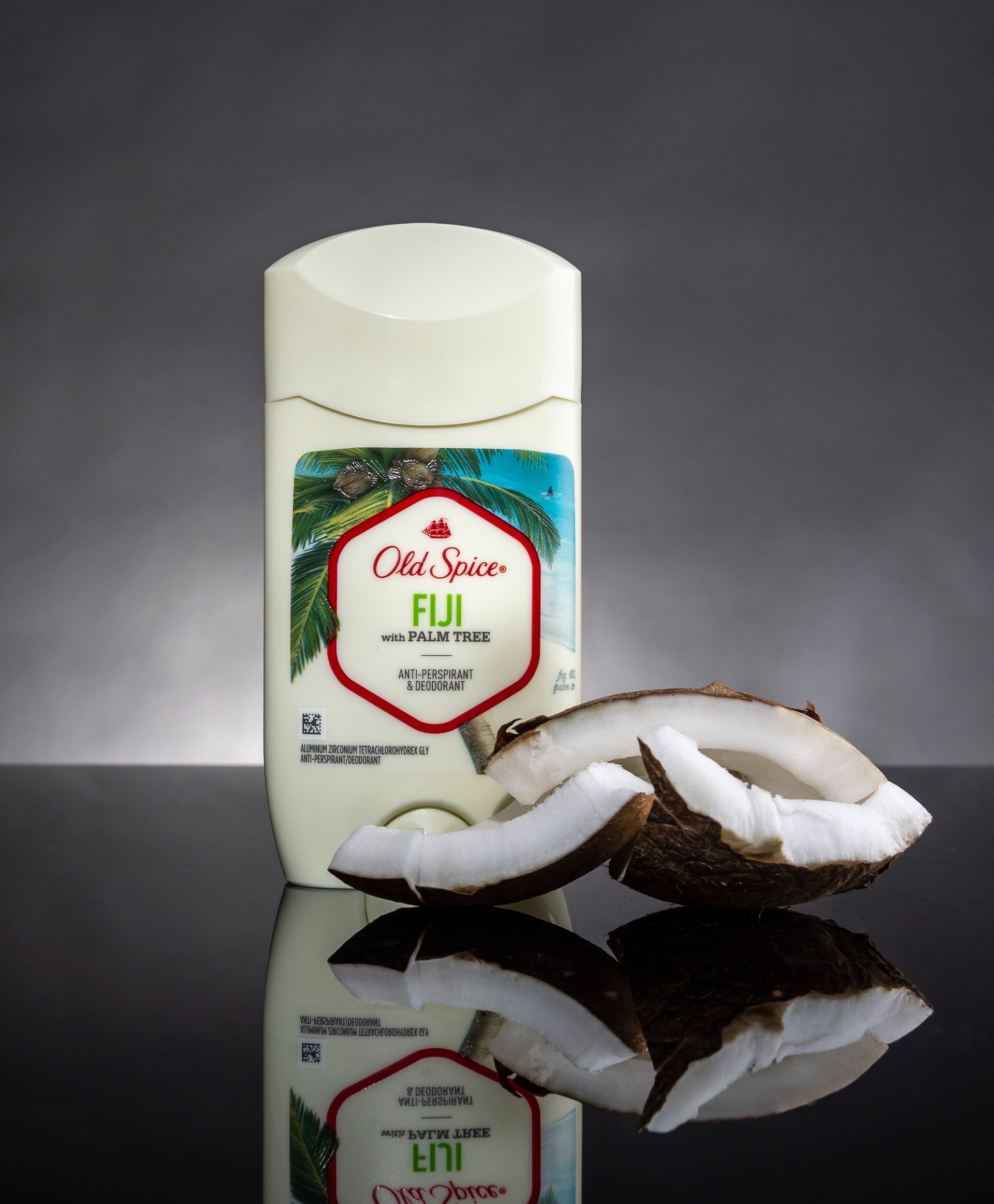 A bottle of old spice fiji next to a coconut