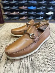 A pair of brown loafers sitting on top of a wooden table.