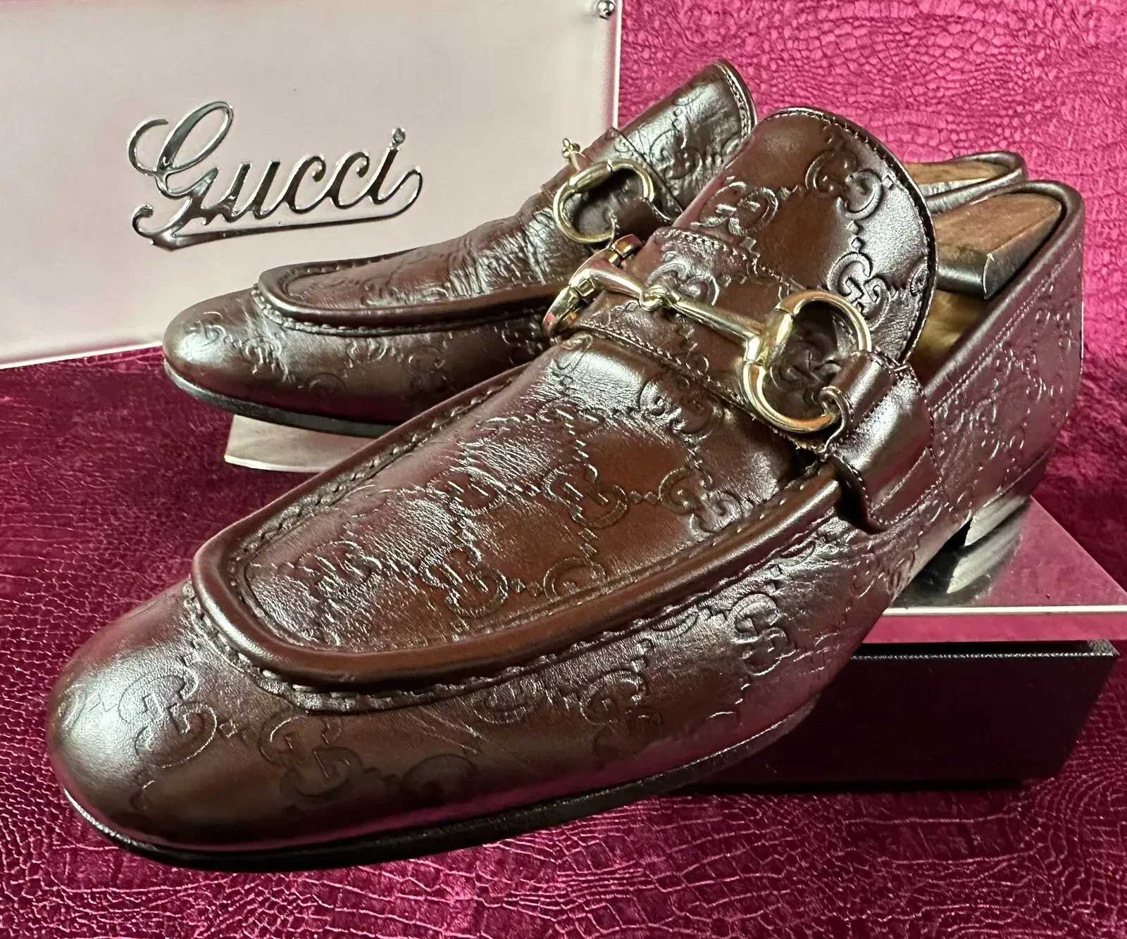 A pair of brown gucci loafers are sitting on top of a box.