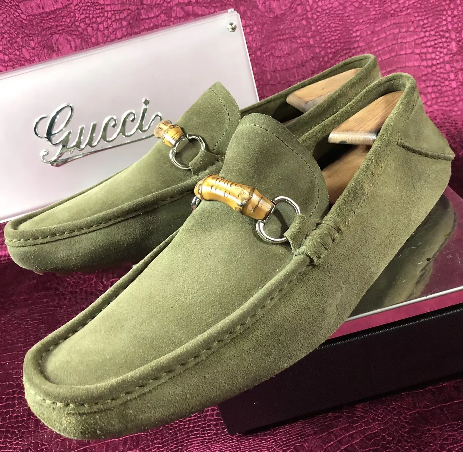 A pair of green gucci loafers with a bamboo buckle