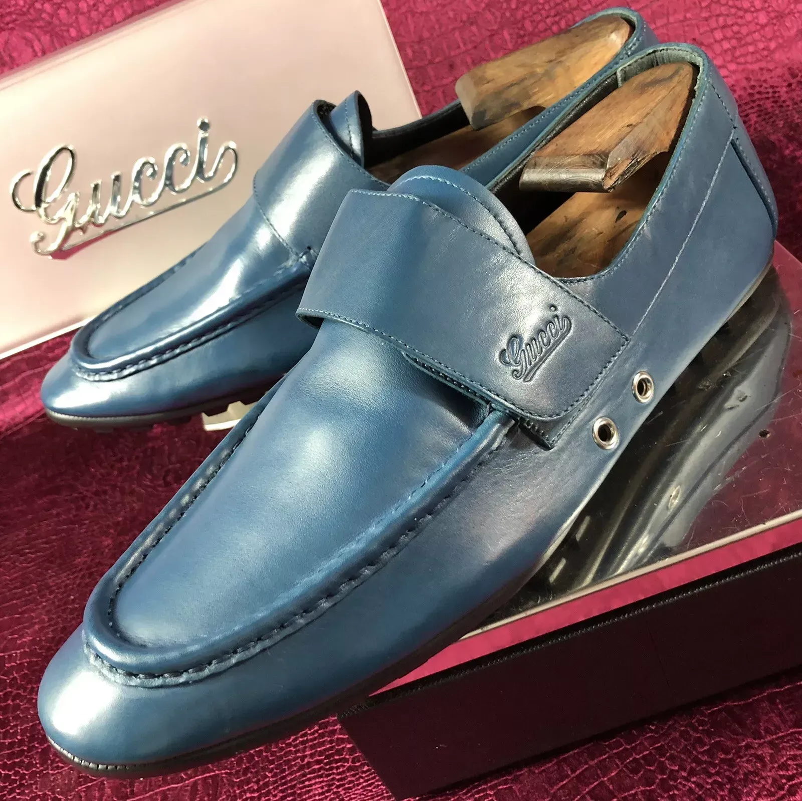 A pair of blue gucci shoes sitting on top of a mirror