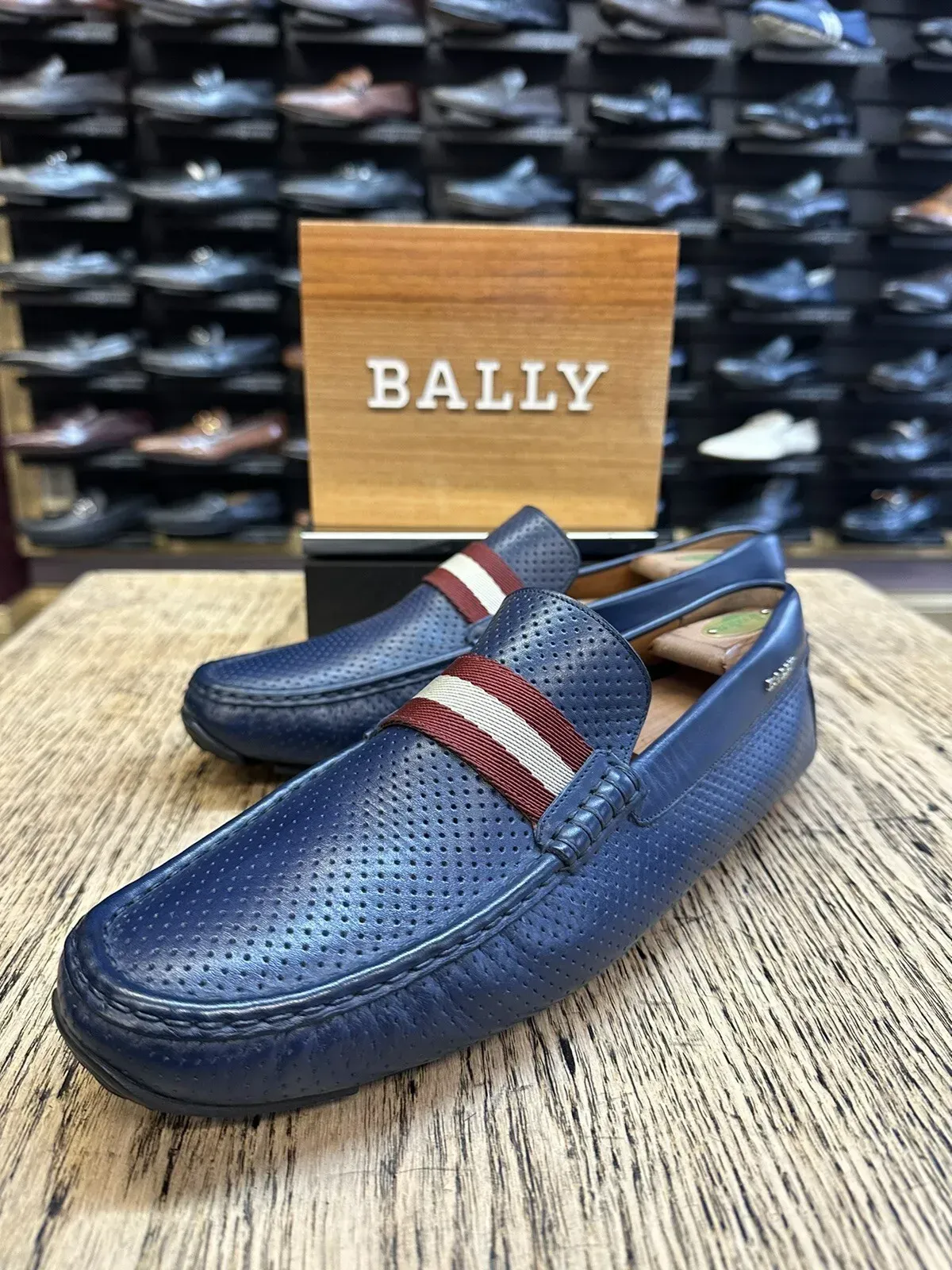 A pair of blue loafers are sitting on top of a wooden table.