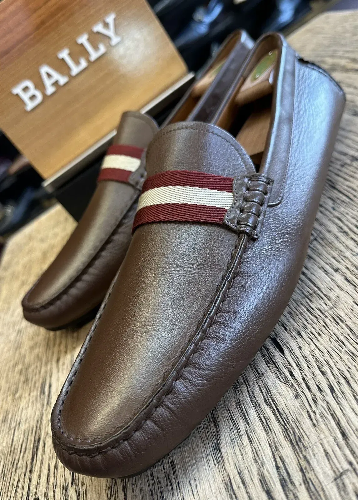A pair of brown loafers are sitting on a wooden table.