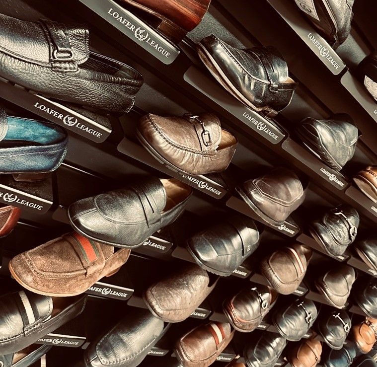 A pair of brown and black shoes are sitting on a glass shelf.
