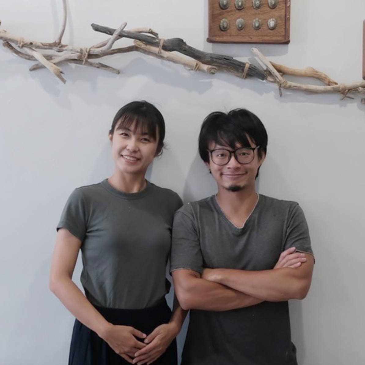 一位男性交叉雙臂，和一位女性並肩站立