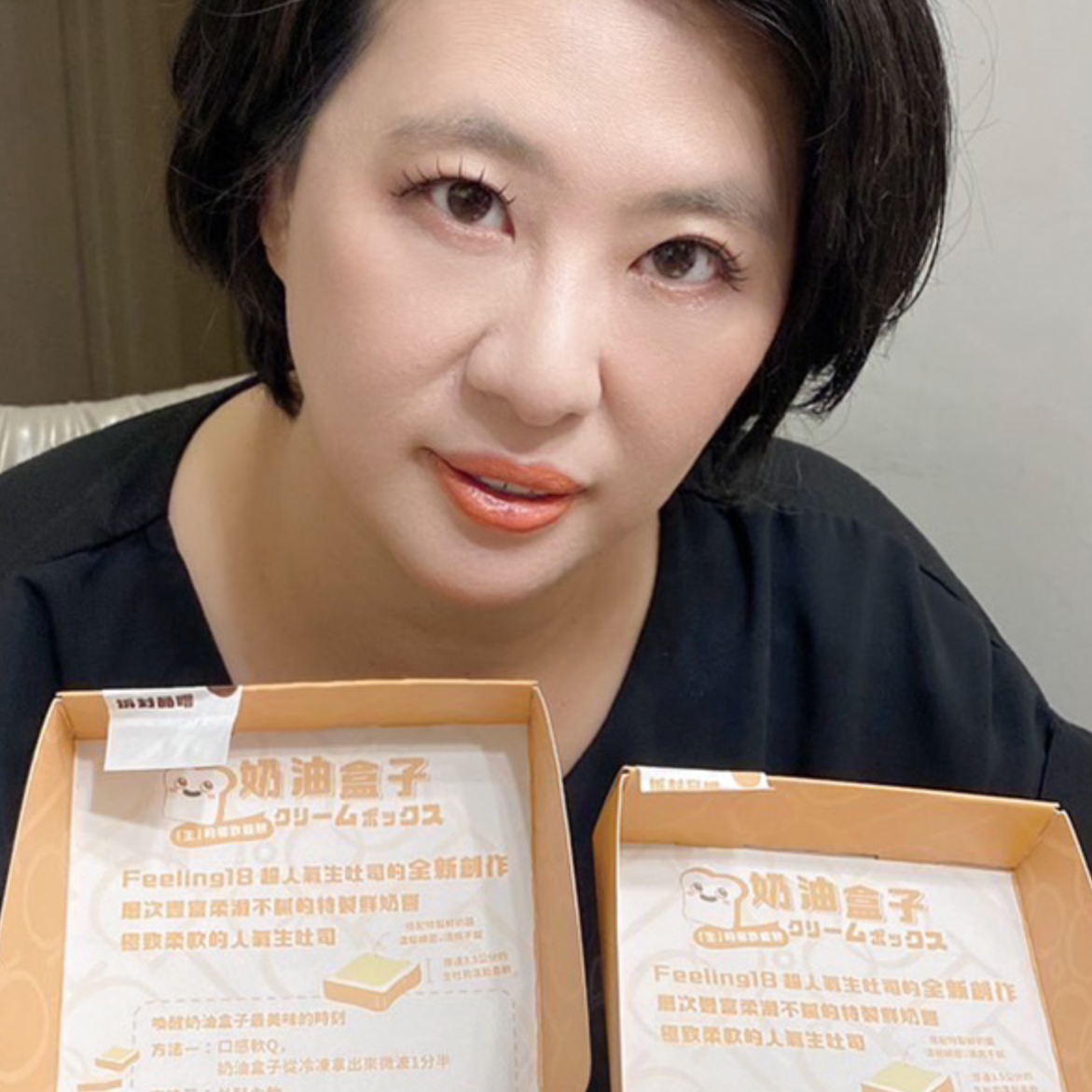 一位女性舉著兩盒食物