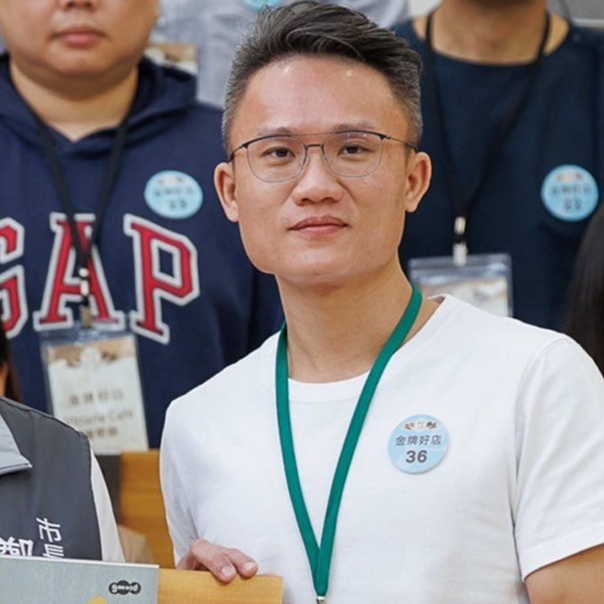 一位戴著眼鏡、穿白色T-shirt的男性