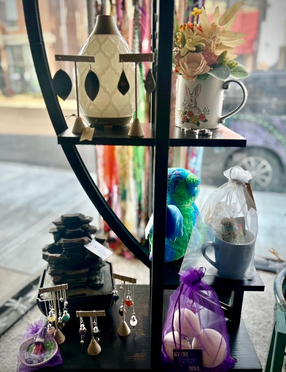 A shelf with a variety of items on it in a store window.