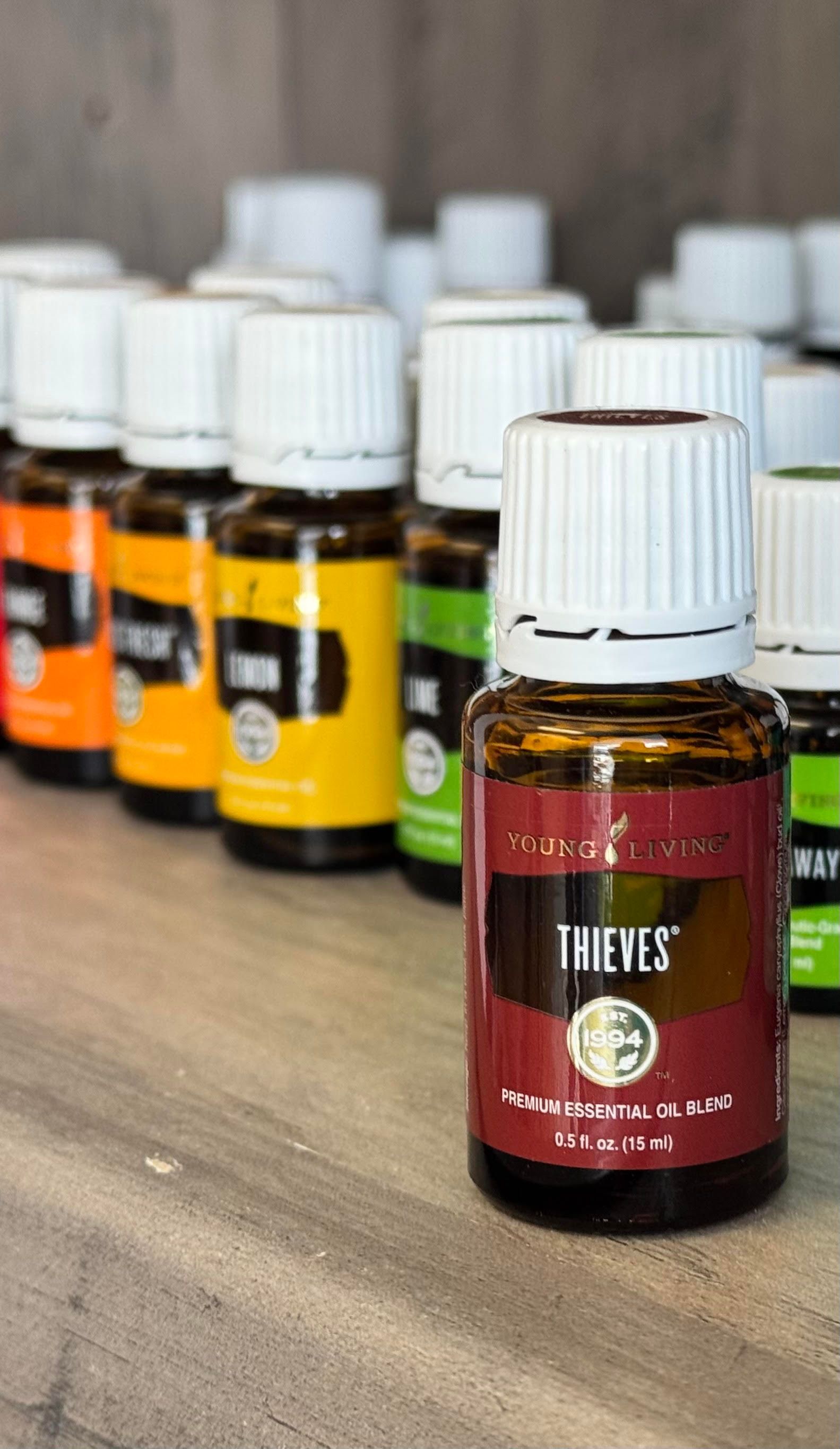 A bottle of thieves essential oil is sitting on a wooden table.