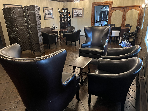 A black and white photo of a sherman house with a car parked in front of it.