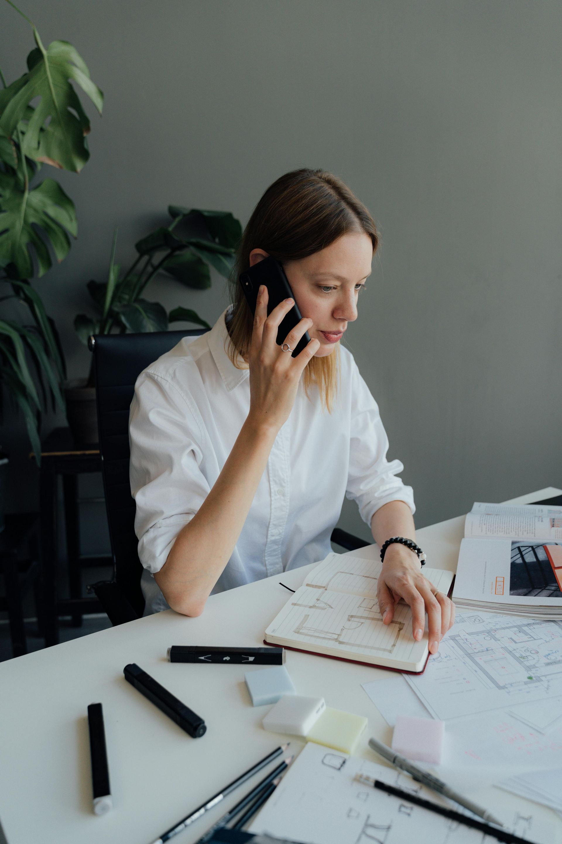 A woman is sitting at a table talking on a cell phone.
