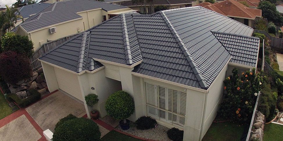 An aerial view of a house with a tiled roof and a driveway.