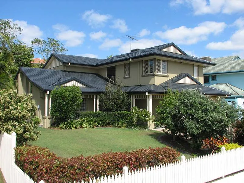 A large house with a white picket fence in front of it