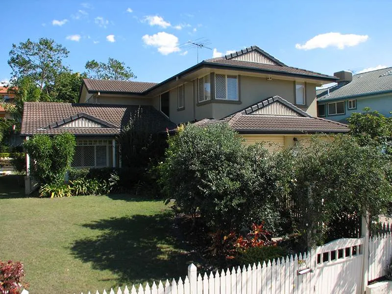 A large house with a white picket fence in front of it