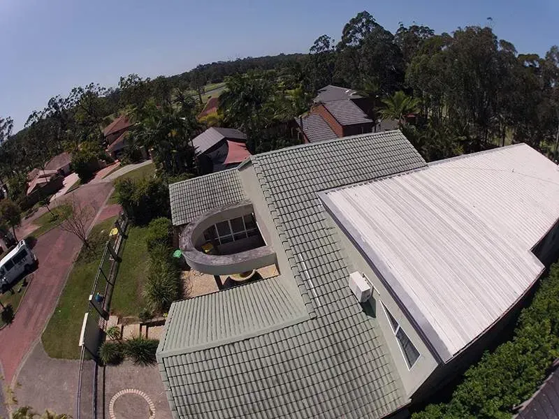 An aerial view of a house with a white roof