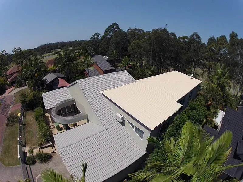 An aerial view of a house with a white roof