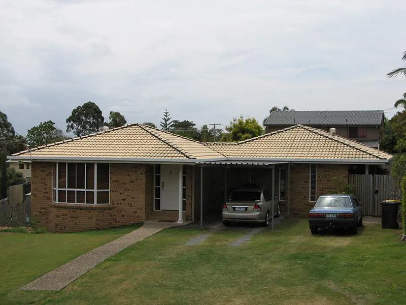A brick house with a car parked in front of it